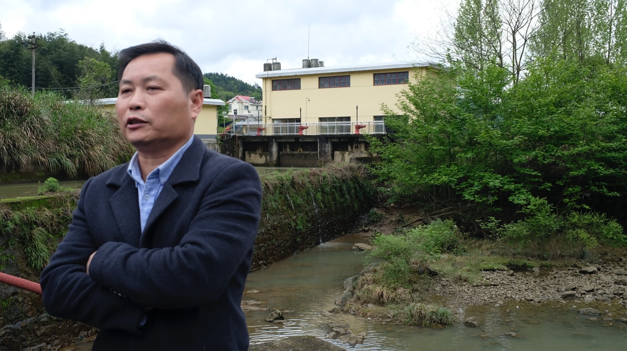 陈太安站在洪沙电站拦河坝上接受采访