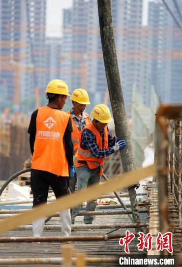 济南新旧动能转换起步区建设“如火如荼”。图中工人正在黄河大道会展中心段建设现场加紧施工。　沙见龙 摄